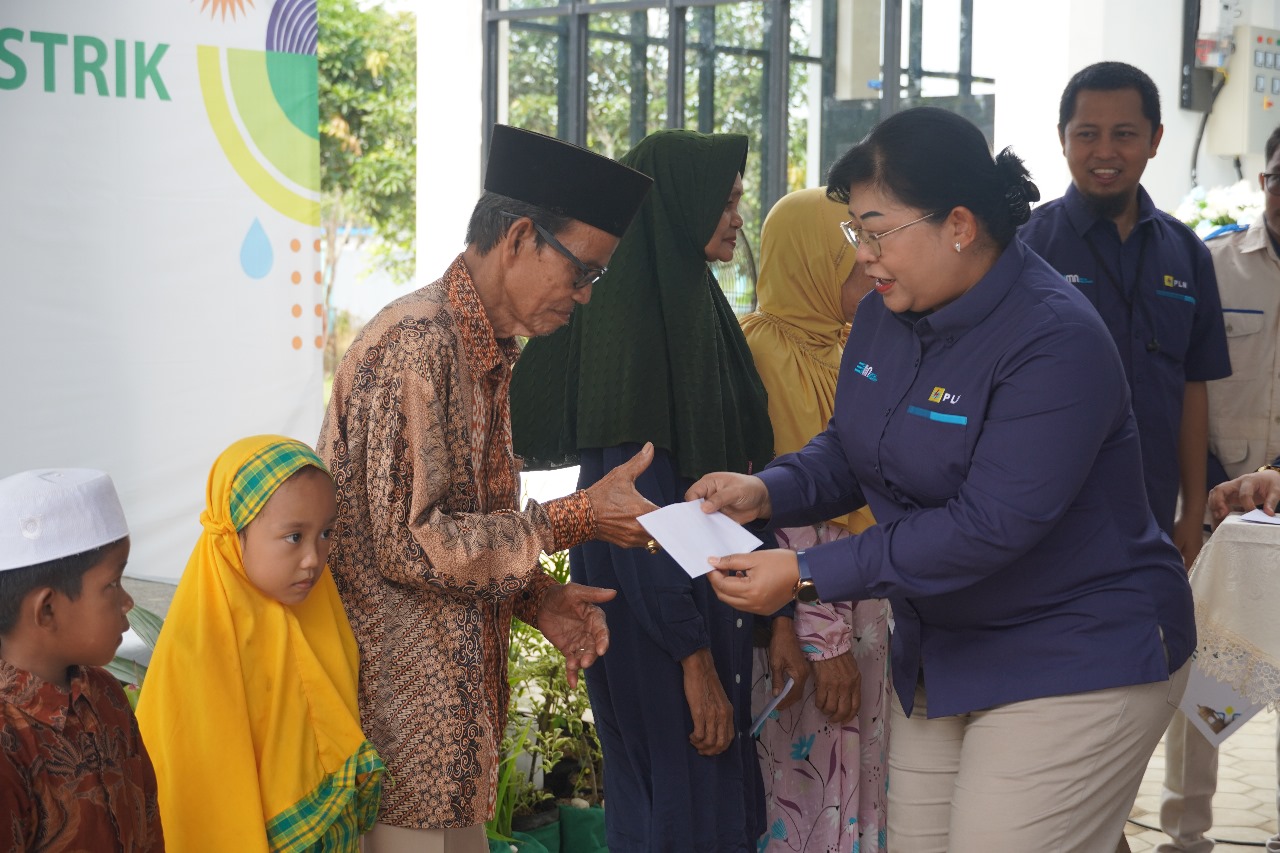Rahayu Arimbi (kanan), Senior Manager Keuangan, Komunikasi dan Umum PLN UIP3B Kalimantan, menyerahkan santunan kepada kaum dhuafa di sekitar lingkungan kerja ULTG Batulicin. FOTO; ISTIMEWA. 