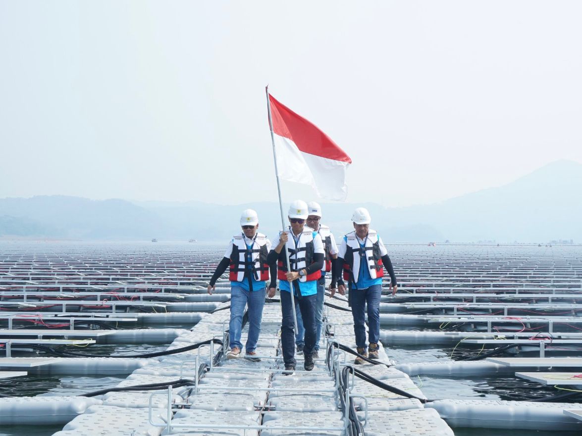 Direktur Utama PT PLN (Persero), Darmawan Prasodjo (kedua dari kiri); didampingi Direktur Manajemen Pembangkitan PLN, Adi Lumakso (kiri); Direktur Utama PLN Nusantara Power, Ruly Firmansyah (kanan); dan Managing Director Masdar Asia Pacific, Sujit S. Parhar (kedua dari kanan). Berjalan diantara panel surya untuk memasang bendera merah putih saat meninjau PLTS terapung Cirata di Purwakarta, Jawa Barat. Kehadiran PLTS ini menjadi bukti bahwa PLN mampu menjadikan transisi energi menjadi sebuah kekuatan untuk meningkatkan ketahanan energi nasional. FOTO; ISTIMEWA. 