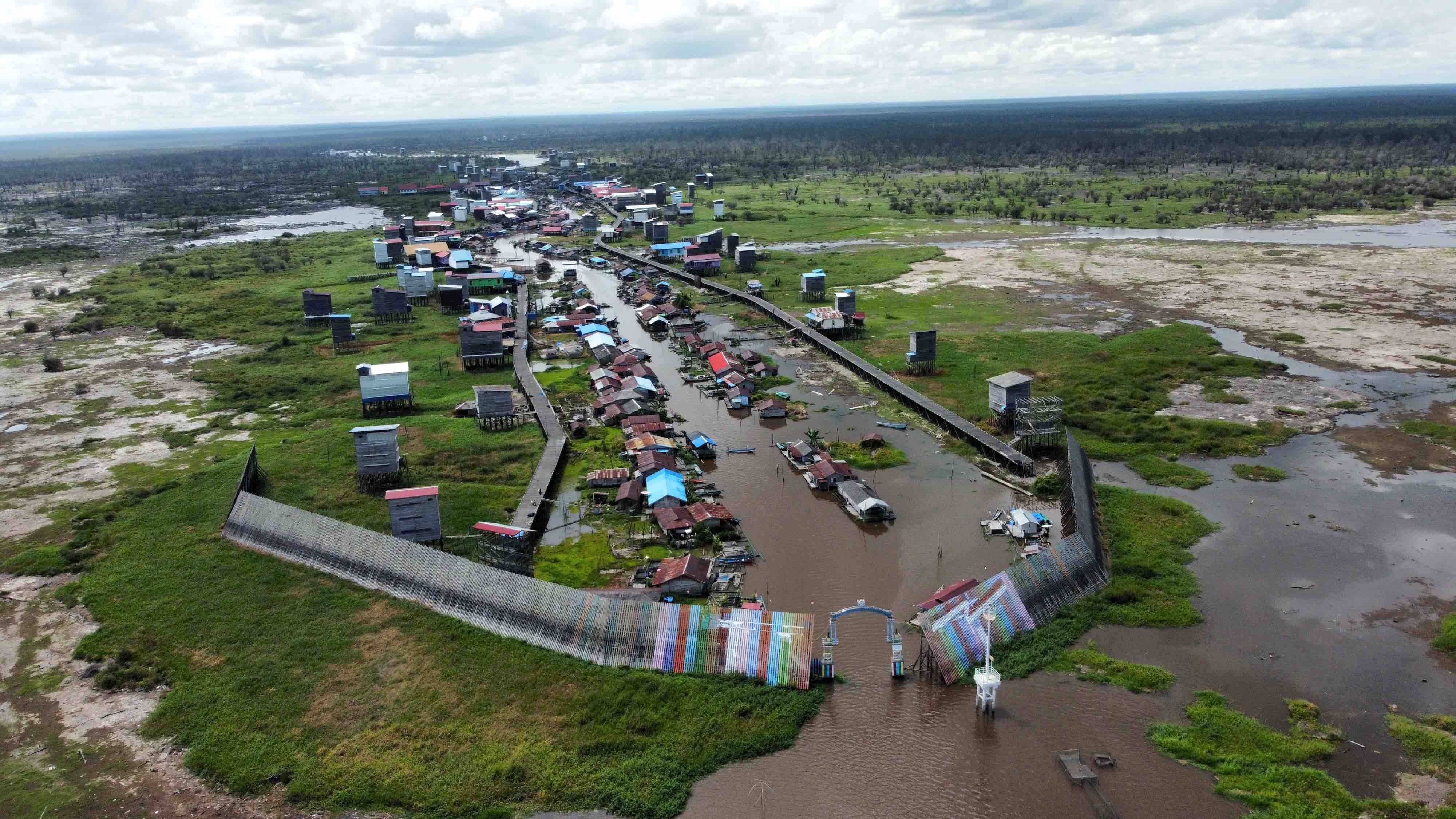 Desa Muara Enggelam, Kecamatan Muara Wis, Kutai Kartanegara ketika kemarau sedang melanda pada September 2023. Gapura tersebut melindungi desa dari angin yang berasal dari Danau Melintang. FOTO: MUHIBAR SOBARY ARDAN-KALTIMKECE.ID