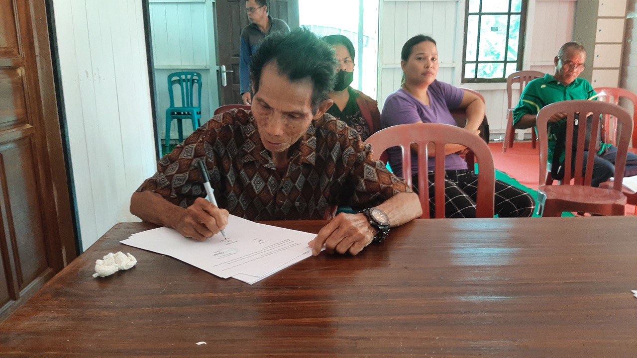 Syahrudin, Tokoh Masyarakat Kampung Penarung menandatangani berita acara kegiatan. FOTO: ISTIMEWA. 