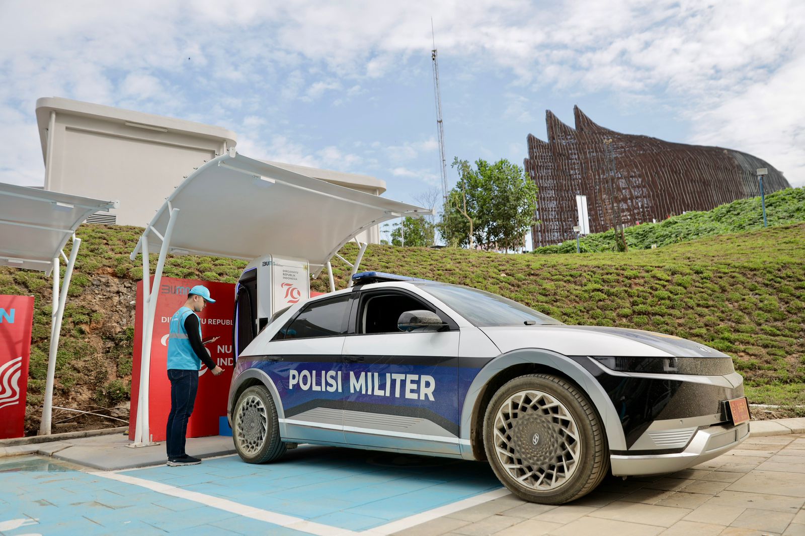Petugas PLN sedang melakukan pengisian daya mobil listrik Polisi Militer di SPKLU Kementerian Sekretariat Negara. FOTO; ISTIMEWA. 
