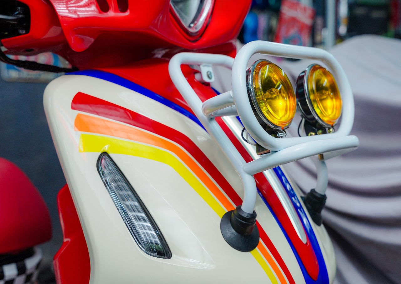 Untuk menambah kesan rally yang kuat pada modifikasi Grand Filano Hybrid "Special Edizione", skutik ini dipasangi aksesoris ikonik seperti cover headlamp merah custom yang menjadi ciri khasnya. FOTO; ISTIMEWA. 