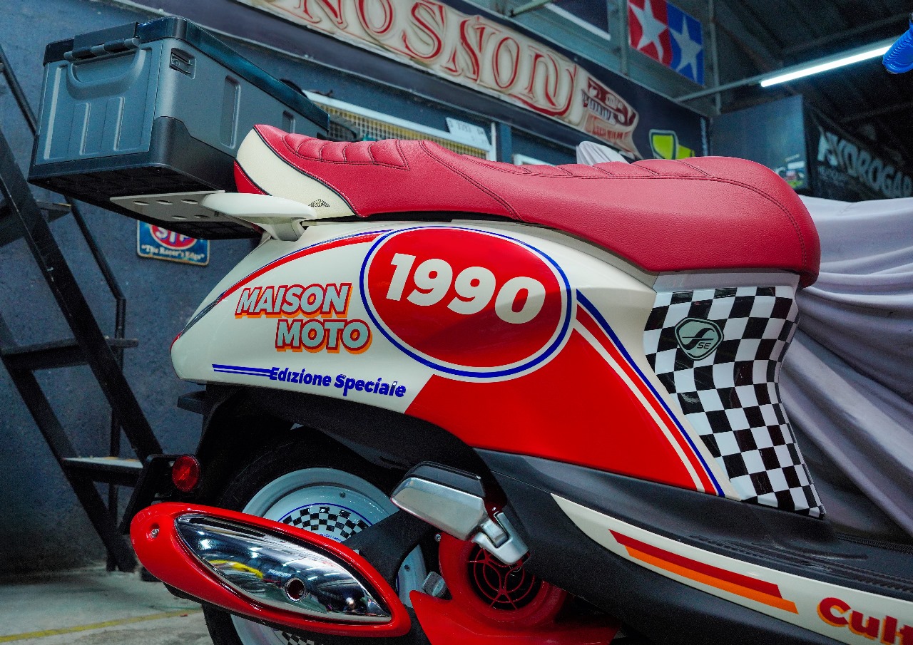 Motif kotak-kotak checkerboard hitam-putih di dek kaki serta warna merah di spakbor depan memperkuat nuansa balap klasik era tersebut. FOTO; ISTIMEWA. 